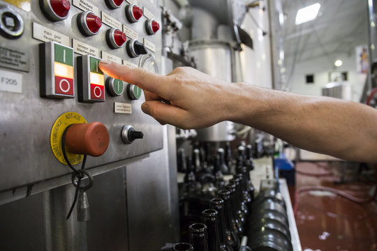Man pressing button in beer bottling plant