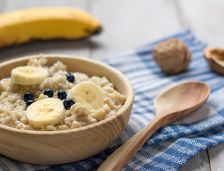 Oatmeal with banana and blueberries. Banana, nuts and a wooden s