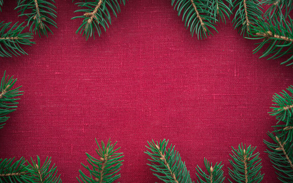 Frame with xmas tree on red canvas background. Merry christmas card. Winter holiday theme. Space for text. Happy New Year.