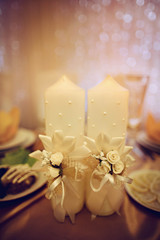 white decorated candles stand on the table