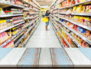 Plank wood or table top with Blurred supermarket and woman shopping.
