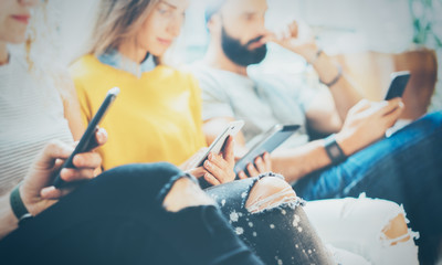 Closeup Group Adult Hipsters Friends Sitting Sofa Using Modern Gadgets.Business Startup Friendship Teamwork Concept.Creative People Working Together Project.Coworking Process Inside Studio.Blurred.