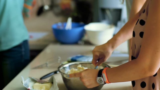 Unrecognizable woman mixes dough in bowl