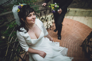 The charming brides stand on the stairs