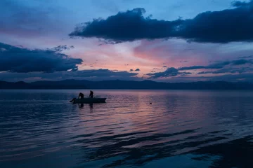 Tuinposter Fishermen on the mountain lake Sevan in Armenia © Oleg Breslavtsev