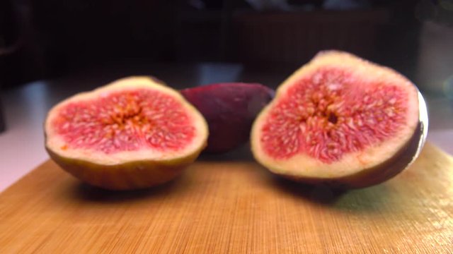 Beautiful female hand taking the half of fig. 4K close up pan shot