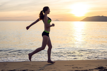 Fototapeta na wymiar Woman Running on the Beach at Sunset