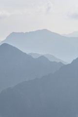 Silhouette of blue mountains in the fog. View of Moldoveanu peak, the highest peak from Romanian Carpathian Mountains range. Seamless background.
