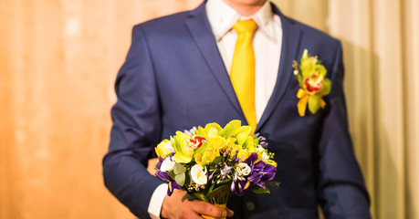 groom holding wedding bouquet, flowers in male hands