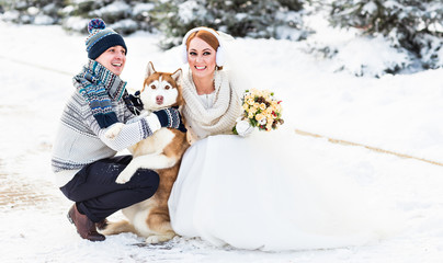Fototapeta na wymiar Wedding couple and a cute dog in winter time