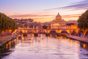 Fototapeta na wymiar Skyline of Rome in a magenta twilight with San Pietro basilica, at Sant'Angelo bridge and Tevere river illuminated by city lights of Roma in Italy