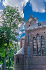 Fototapeta premium old style church with tree and clock tower