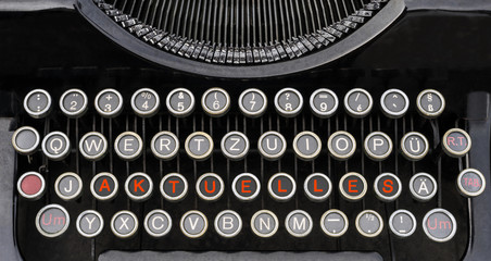 Wort Aktuelles auf der Tastatur einer antiken Schreibmaschine