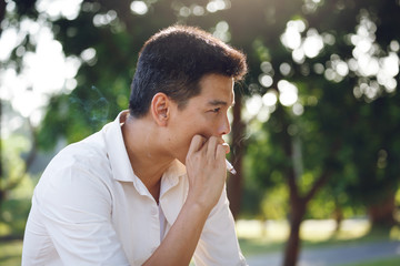 Man smoking and blurred tree Background