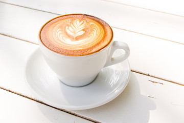 Latte coffee art on the old colored wood plank