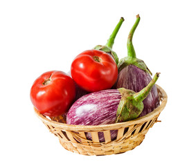Aubergines and tomatoes in basket  isolated on white background