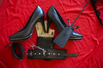prostitute or striptease concept, 50 euro banknot with sex toys on red bed