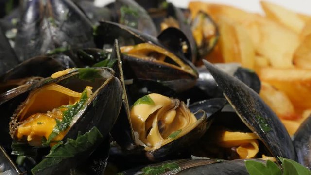 Tasty meal Mytilus edulis and fried potato sliced chips 4K 2160p 30fps UltraHD footage - Blue common mussel with french fries and lemon 4K 3840X2160 UHD video 