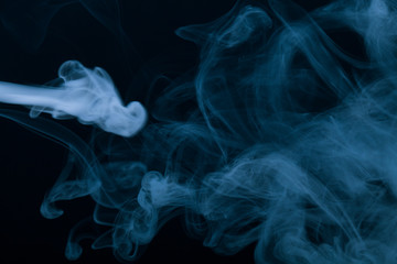 Obraz premium Cloud of smoke on black background. Selective focus. Toned