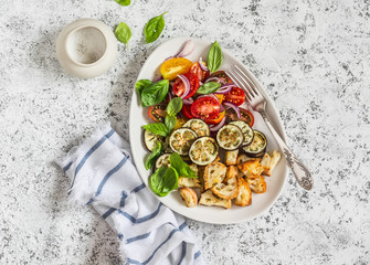 Roasted eggplant panzanella on a light background, top view.