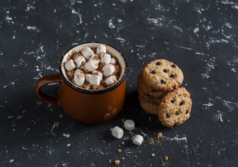 Hot chocolate with marshmallows and chocolate chips oatmeal cookies on a dark background. - obrazy, fototapety, plakaty