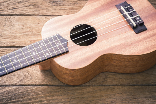 Close up of ukulele on old wood background, vintage color tone