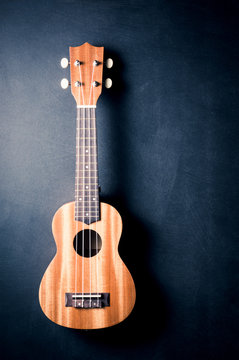 ukulele with shadow on space of art dark and rough background, vintage color tone