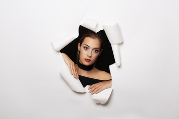 Woman coming out of an white paper background