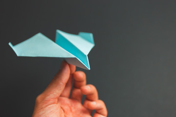 Blue paper airplane origami in hand