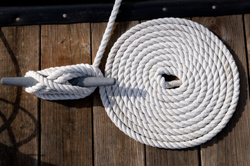 Coiled White Rope with Anchor Point and Wooden Dock