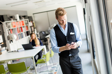 Mann with mobile phone in office