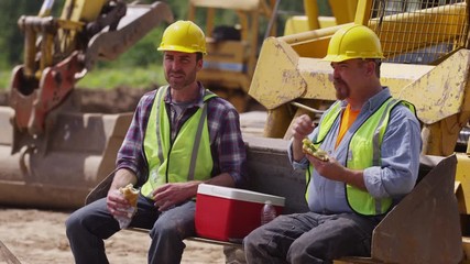 Two blue collar workers having lunch on job site