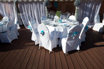 Chairs with blue ribbons on the wedding celebration on the outdoor deck