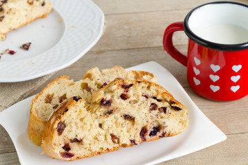 Fruitbread slices with milk in a heart-shaped red cup.