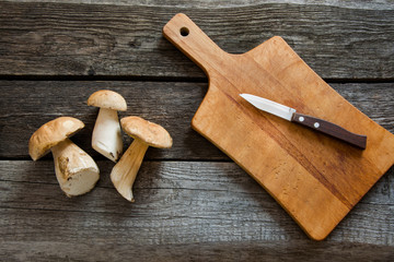 Fresh white mushrooms from  forest on a rustic wooden board, overhead view.