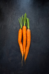 Top view of carrots on black slate background