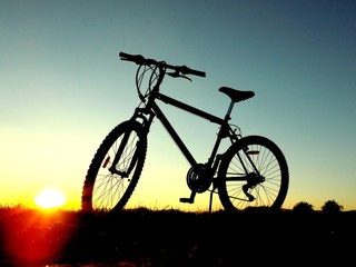 Fototapeta na wymiar Mountain bike on hill during sunset