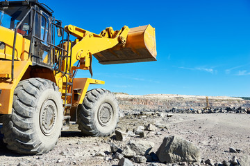 Fototapeta premium wheel loader excavator at granite or iron ore opencast mine