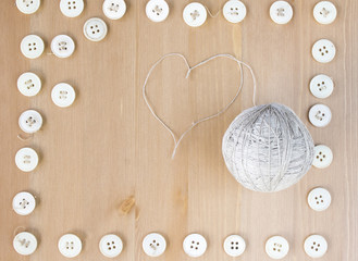 Vintage sewing buttons frame and ball of linen heart shaped thread in the middle. Flat lay, top view. Copy space