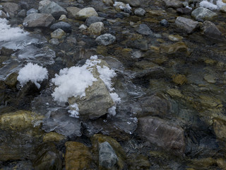 Stream flowing over rocks in winter, Lake Louise, Banff National