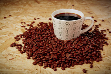 Hot coffee with beans on wooden texture