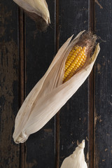 Ripe yellow corn on a dark old wooden table. Country style.