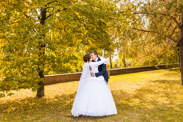 Groom and Bride in autumn park.