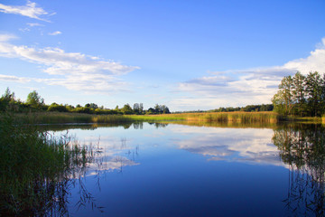 Fototapeta na wymiar Fishing rod in hand on a background of lake
