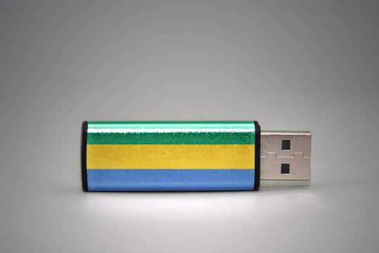 usb flash drive with the national flag of gabon on gray background.