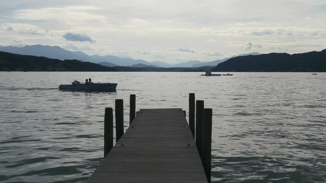 Boat passing by wooden dock in a big lake