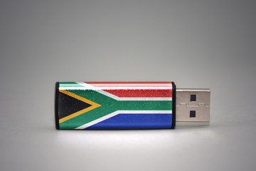 usb flash drive with the national flag of south africa on gray background.