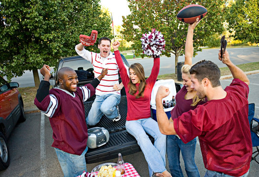 Tailgating: Group Of Friends Cheering While Listening To Footbal