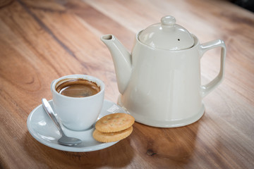 Cup of espresso with tea pot