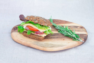 Sandwich with rye bread , tomato , ham and cheese with rosemary close